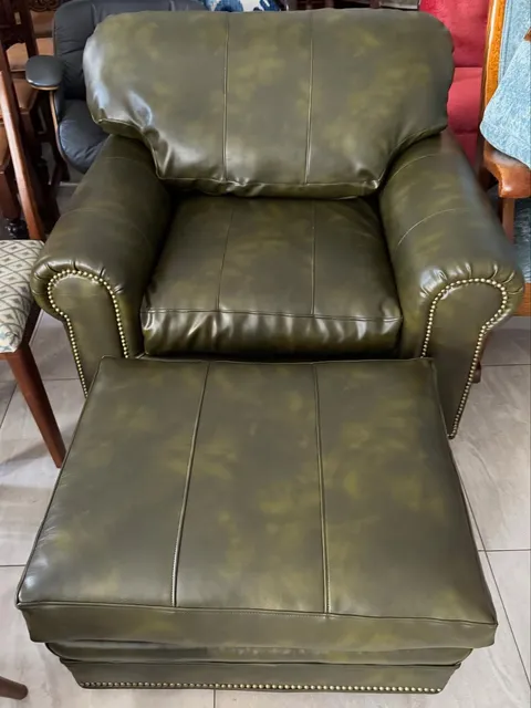 Before and after reupholstery of a leather club chair and ottoman with brass nailhead trim