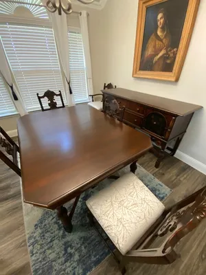 Restored formal dining table with sideboard and reupholstered chairs