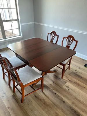 Refinished dining table with shield-back chairs and upholstered seats