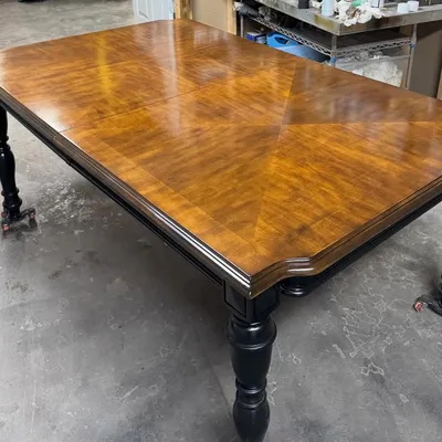Refinished dining table with rich wood grain top and black turned legs by ARED
