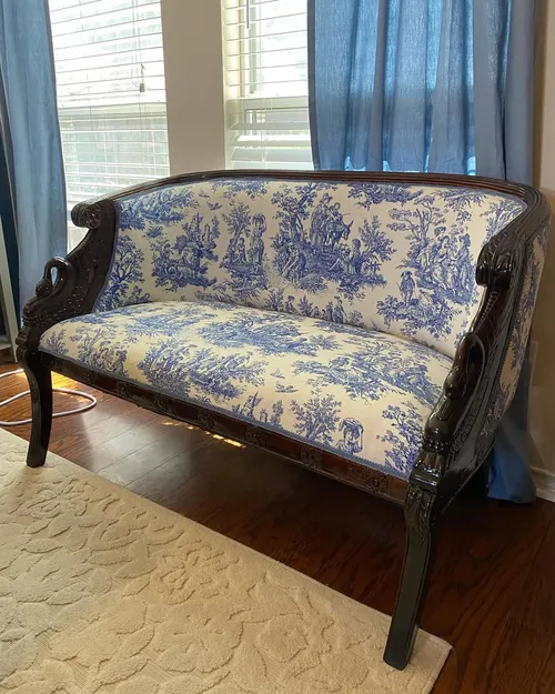 Reupholstered antique settee with blue and white toile fabric and carved swan arm details