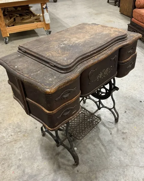 Before and after restoration of an antique treadle sewing table - before