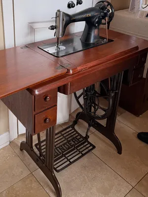 Restored Singer treadle sewing machine cabinet with cherry finish and cast iron base